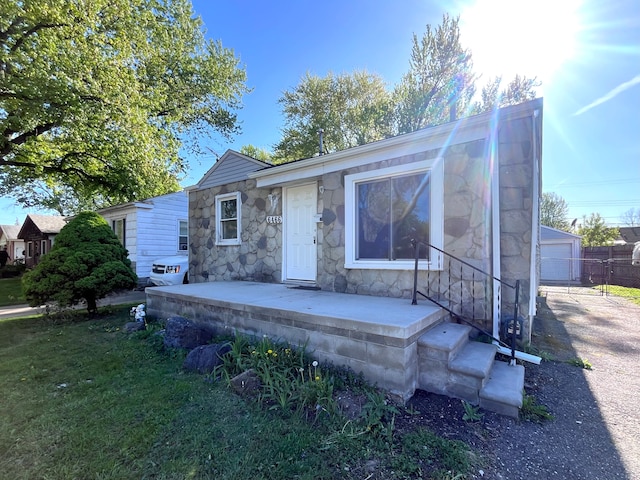 view of front of home with stone siding, an outbuilding, and a garage