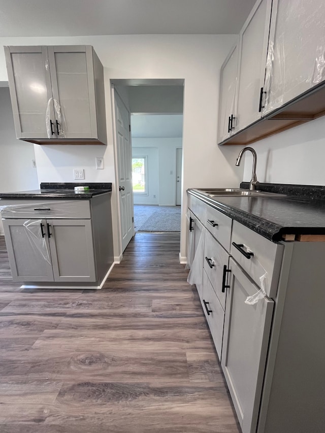kitchen featuring dark countertops, gray cabinets, and dark wood-type flooring