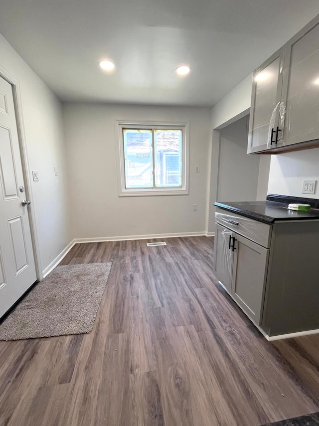 kitchen with dark countertops, dark wood-style floors, baseboards, gray cabinets, and recessed lighting