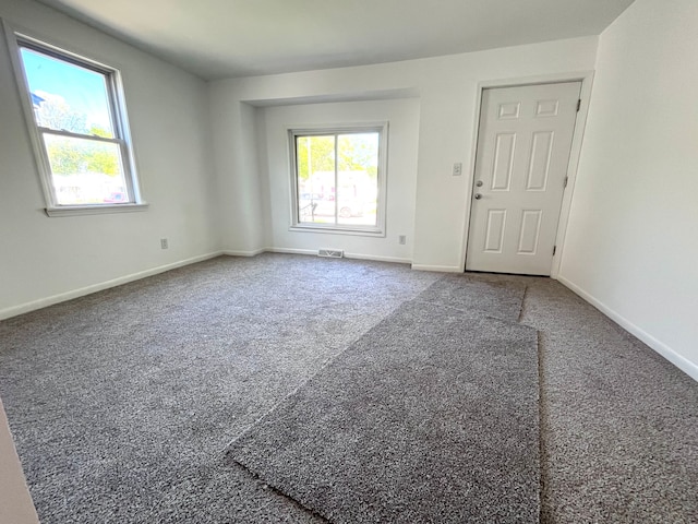 carpeted empty room featuring baseboards