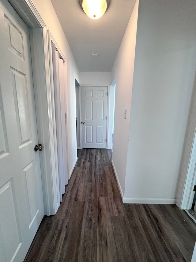 hall with dark wood-style floors and baseboards