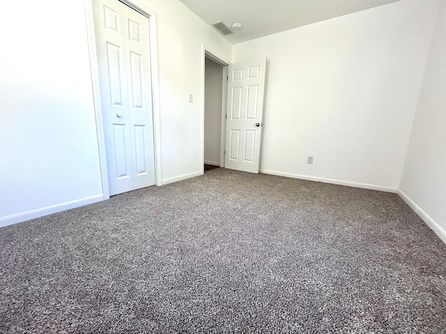 unfurnished bedroom featuring carpet, baseboards, and a closet