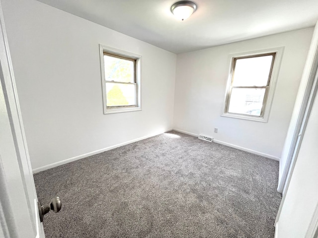 unfurnished room featuring healthy amount of natural light, carpet floors, and baseboards