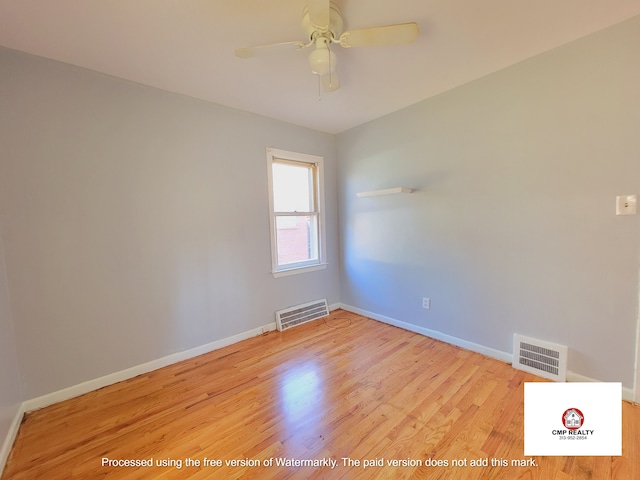 empty room featuring a ceiling fan, light wood-type flooring, and baseboards