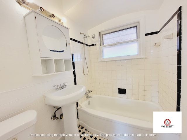 bathroom with shower / tub combination, toilet, and tile walls