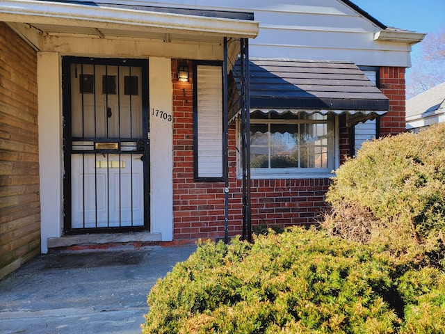 doorway to property featuring brick siding