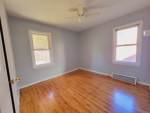 spare room with light wood finished floors, baseboards, and ceiling fan