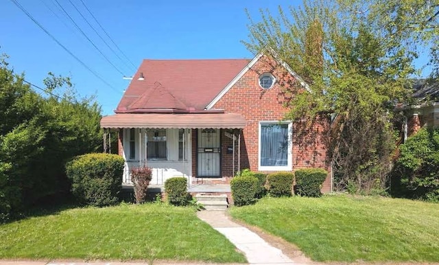 11301 Coyle St, Detroit, MI 48227 - view of front of home with a porch, a front yard, and brick siding