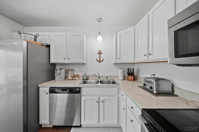 5541 Pleasant Valley Rd, Manitou Beach, MI 49253 - kitchen with appliances with stainless steel finishes, white cabinets, light countertops, and decorative light fixtures