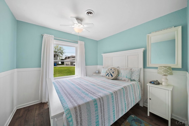 5541 Pleasant Valley Rd, Manitou Beach, MI 49253 - bedroom with wainscoting, dark wood-style flooring, and a ceiling fan