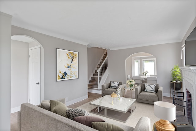 15470 Murray Hill St, Detroit, MI 48227 - living room featuring arched walkways, a fireplace with flush hearth, wood finished floors, stairs, and baseboards