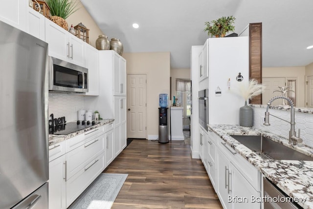 2657 Leffingwell Ave NE, Grand Rapids, MI 49525 - kitchen with appliances with stainless steel finishes, a sink, tasteful backsplash, white cabinets, and recessed lighting