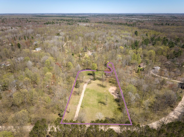 aerial overview of property's location featuring property boundaries highlighted and a heavily wooded area