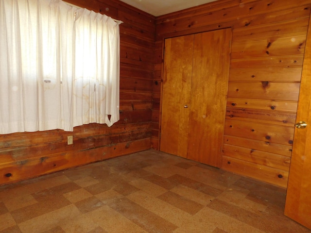 unfurnished room featuring tile patterned floors and wood walls