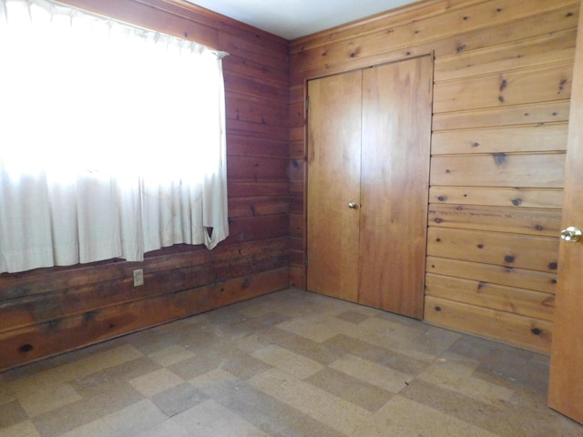 bedroom with wood walls, light flooring, and a closet