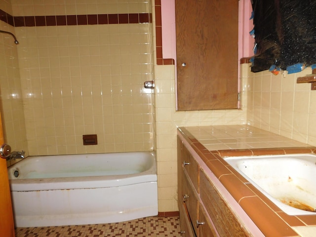 full bath featuring vanity, washtub / shower combination, and tasteful backsplash