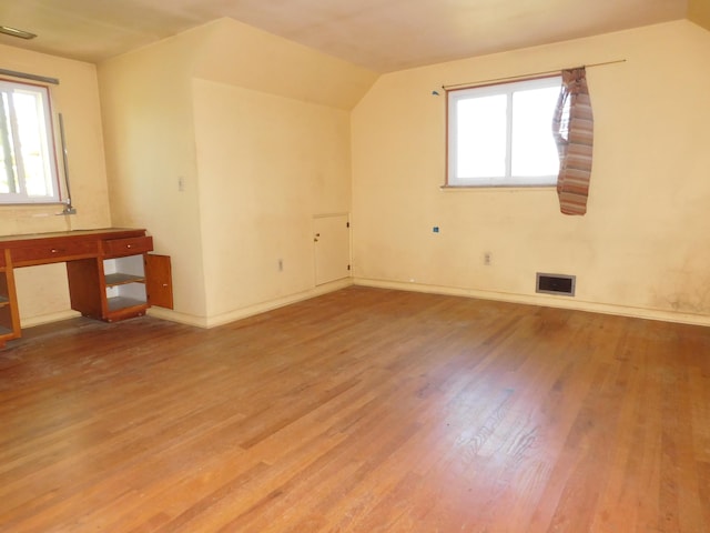 bonus room with wood finished floors, baseboards, and vaulted ceiling