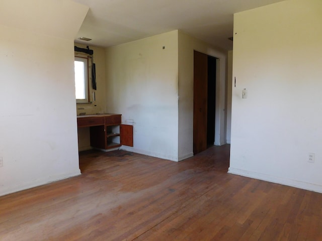 unfurnished room with wood finished floors and baseboards