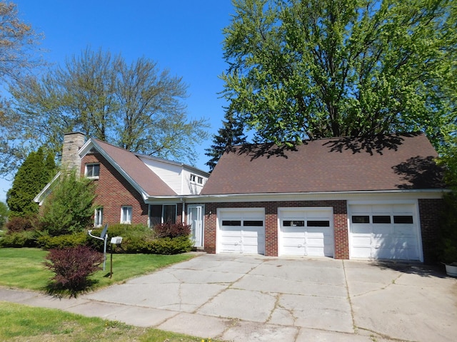 view of front of house featuring an attached garage, a chimney, driveway, and brick siding