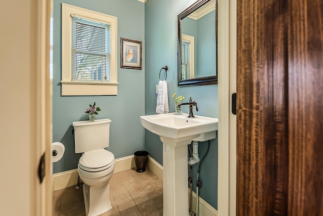 half bath featuring toilet, baseboards, and tile patterned flooring