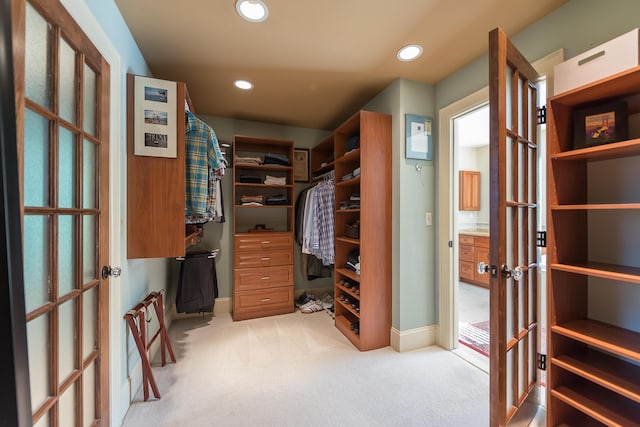 walk in closet with carpet floors and french doors