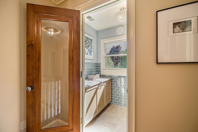 bathroom with tile patterned flooring, tile walls, and vanity