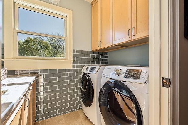 laundry room featuring cabinet space, washing machine and dryer, and light tile patterned flooring