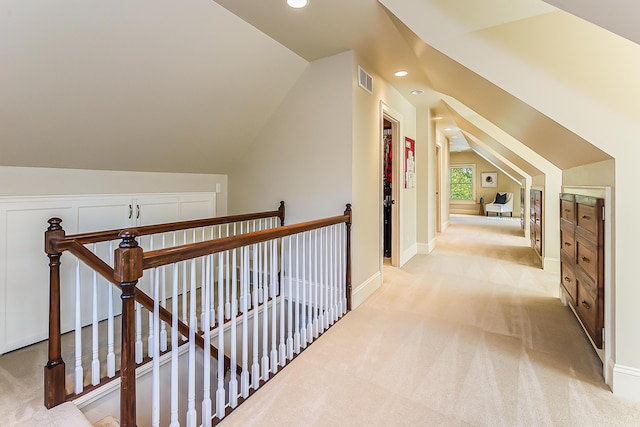 hall with an upstairs landing, lofted ceiling, light carpet, recessed lighting, and baseboards