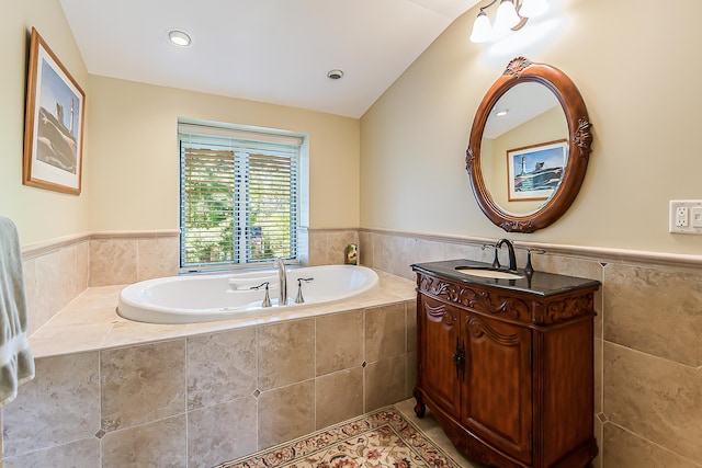 bathroom with a wainscoted wall, a garden tub, tile walls, vanity, and tile patterned floors