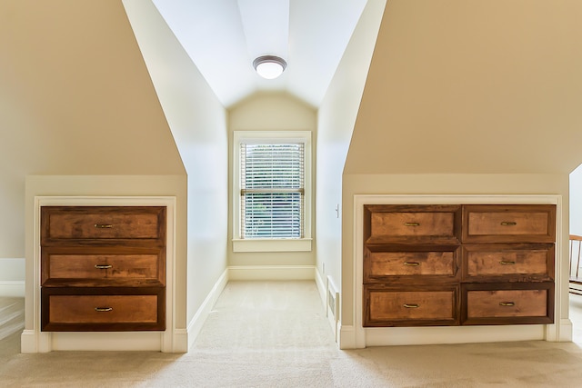 additional living space with light colored carpet, lofted ceiling, and baseboards