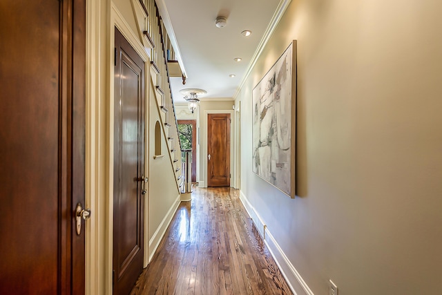 hallway featuring ornamental molding, dark wood finished floors, baseboards, and recessed lighting