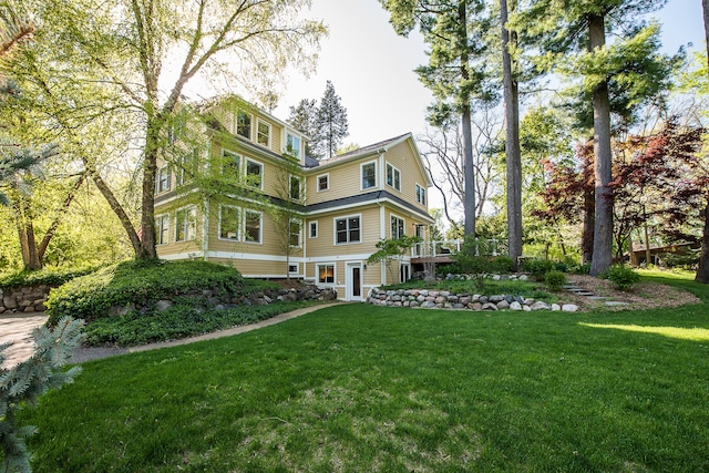 view of side of home featuring a lawn and a deck