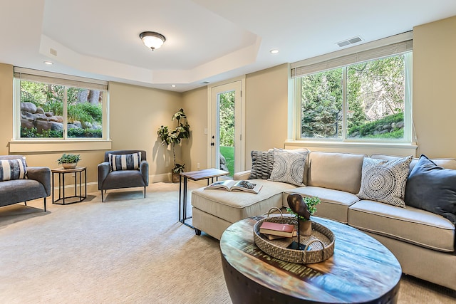 living room featuring light colored carpet, healthy amount of natural light, recessed lighting, baseboards, and a raised ceiling
