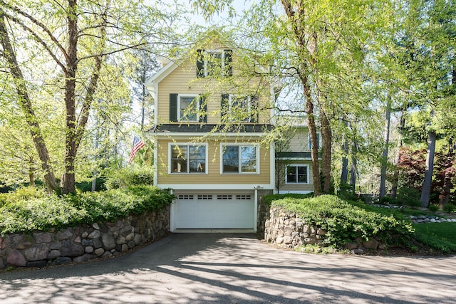 view of front of home with asphalt driveway and a garage