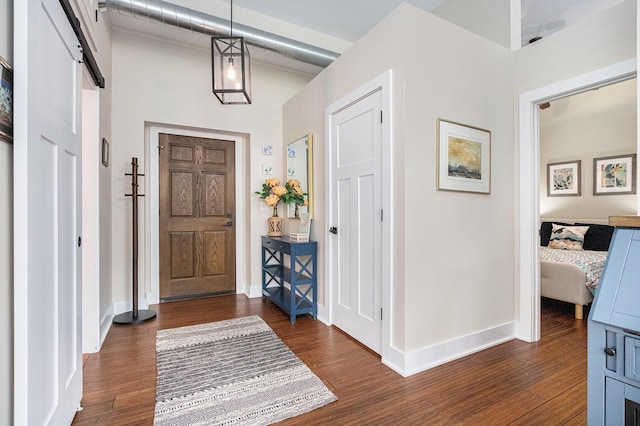 2214 S State St Unit 108, Saint Joseph, MI 49085 - entryway with dark wood-style floors, baseboards, a barn door, and a towering ceiling