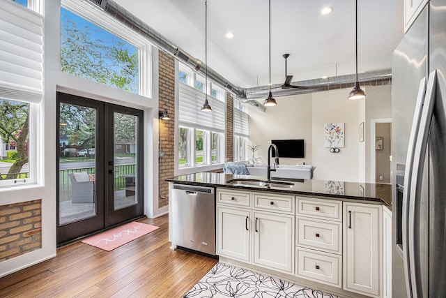 2214 S State St Unit 108, Saint Joseph, MI 49085 - kitchen featuring appliances with stainless steel finishes, a sink, french doors, light wood finished floors, and dark stone countertops