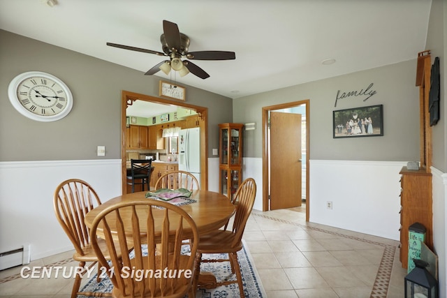 919 E Salzburg Rd, Bay City, MI 48706 - dining area featuring light tile patterned floors, a ceiling fan, baseboard heating, and a wainscoted wall