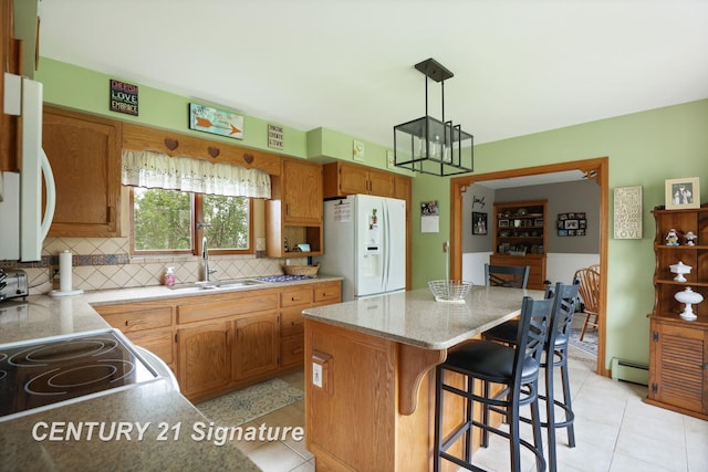 919 E Salzburg Rd, Bay City, MI 48706 - kitchen with white fridge with ice dispenser, a sink, baseboard heating, a kitchen island, and decorative backsplash