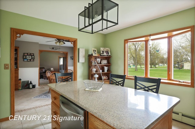 919 E Salzburg Rd, Bay City, MI 48706 - kitchen with a baseboard radiator, light tile patterned floors, light stone countertops, stainless steel dishwasher, and a ceiling fan