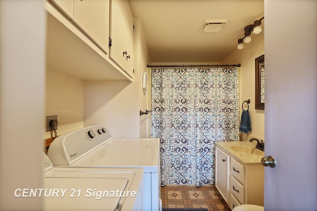 919 E Salzburg Rd, Bay City, MI 48706 - laundry area featuring washing machine and clothes dryer, cabinet space, and dark flooring