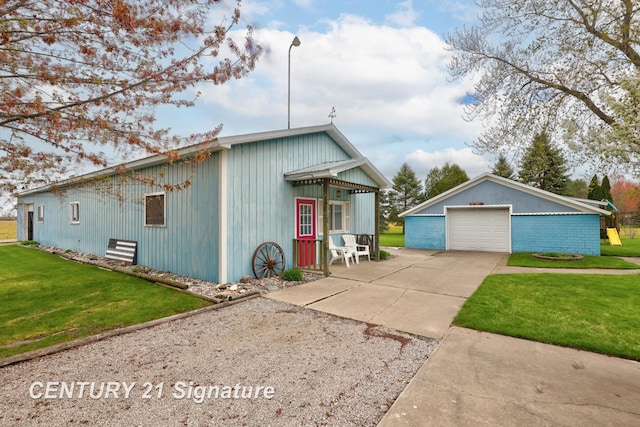 919 E Salzburg Rd, Bay City, MI 48706 - view of front of property featuring concrete driveway, a detached garage, an outbuilding, and a front yard
