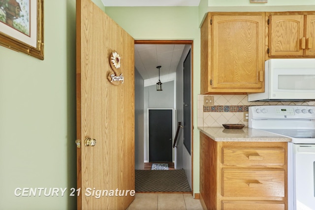 919 E Salzburg Rd, Bay City, MI 48706 - kitchen with white appliances, decorative backsplash, light countertops, and light tile patterned floors