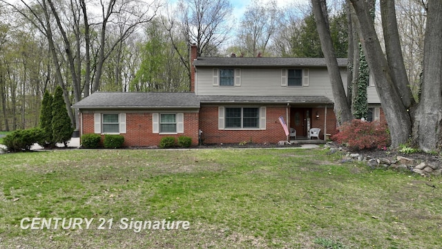 traditional-style house with a chimney, brick siding, and a front yard