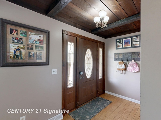 entrance foyer with wood ceiling, beam ceiling, a chandelier, wood-type flooring, and healthy amount of natural light