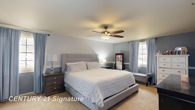bedroom featuring light colored carpet, a ceiling fan, and baseboards