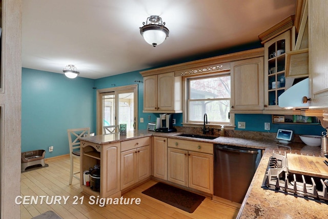 kitchen featuring stainless steel dishwasher, light brown cabinets, a sink, open shelves, and light wood finished floors
