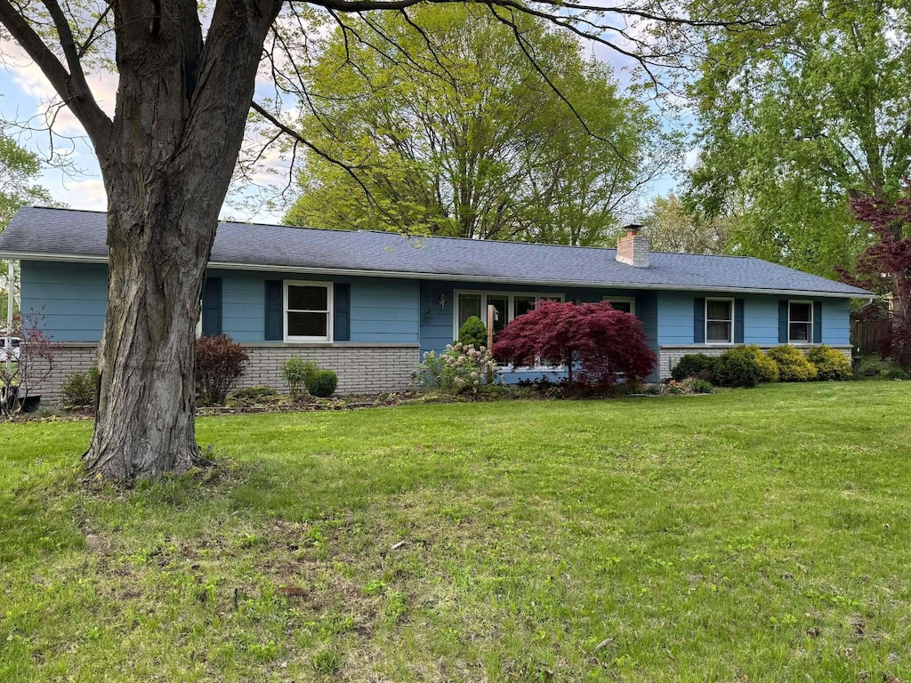 3321 Sandra Dr, Kalamazoo, MI 49004 - ranch-style house with a chimney, a front yard, and brick siding