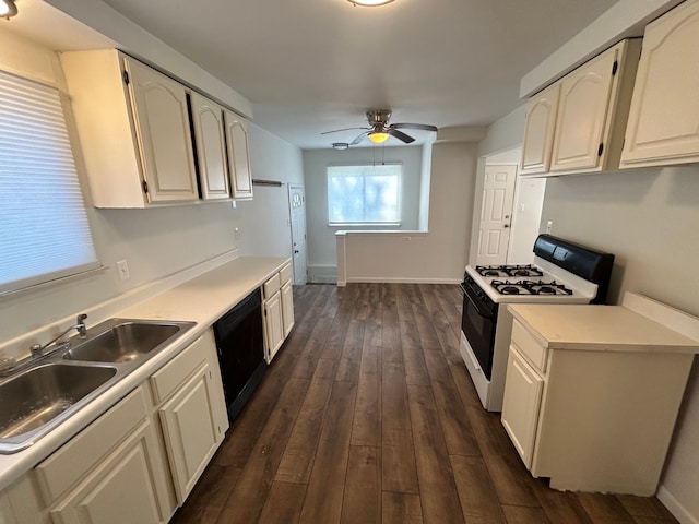 kitchen featuring gas range, a sink, dishwasher, a ceiling fan, and dark wood finished floors