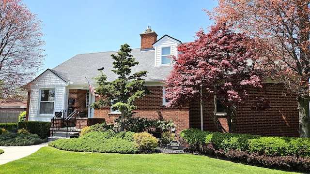28051 Garfield St, Roseville, MI 48066 - new england style home with a chimney, a front yard, brick siding, and a shingled roof