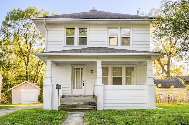 american foursquare style home featuring covered porch, an outdoor structure, a shingled roof, a garage, and driveway
